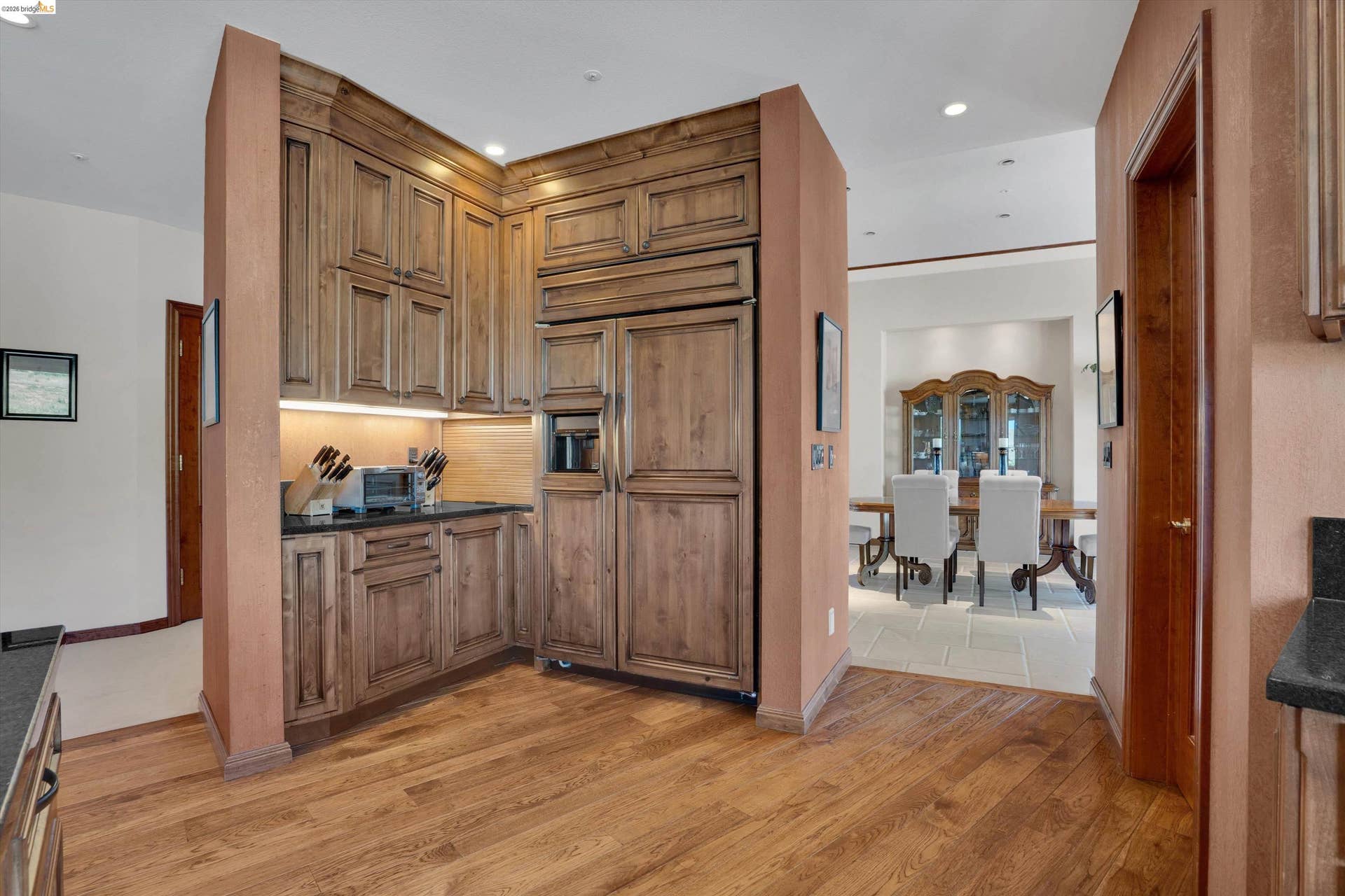 Wood-finish flooring throughout, complemented by custom wood cabinetry and integrated appliances