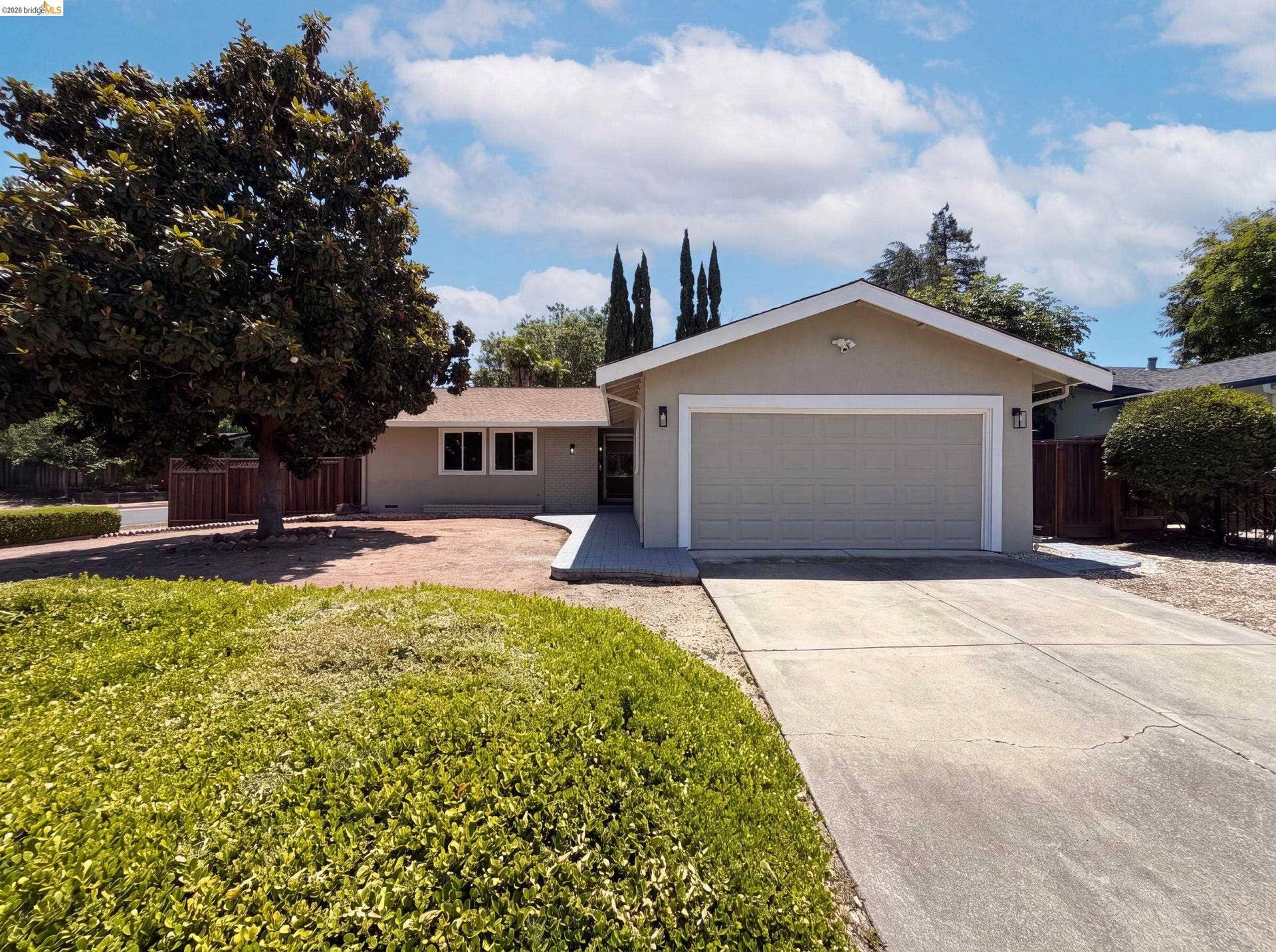 Single-story exterior with a two-car garage, concrete driveway, and neutral-colored siding