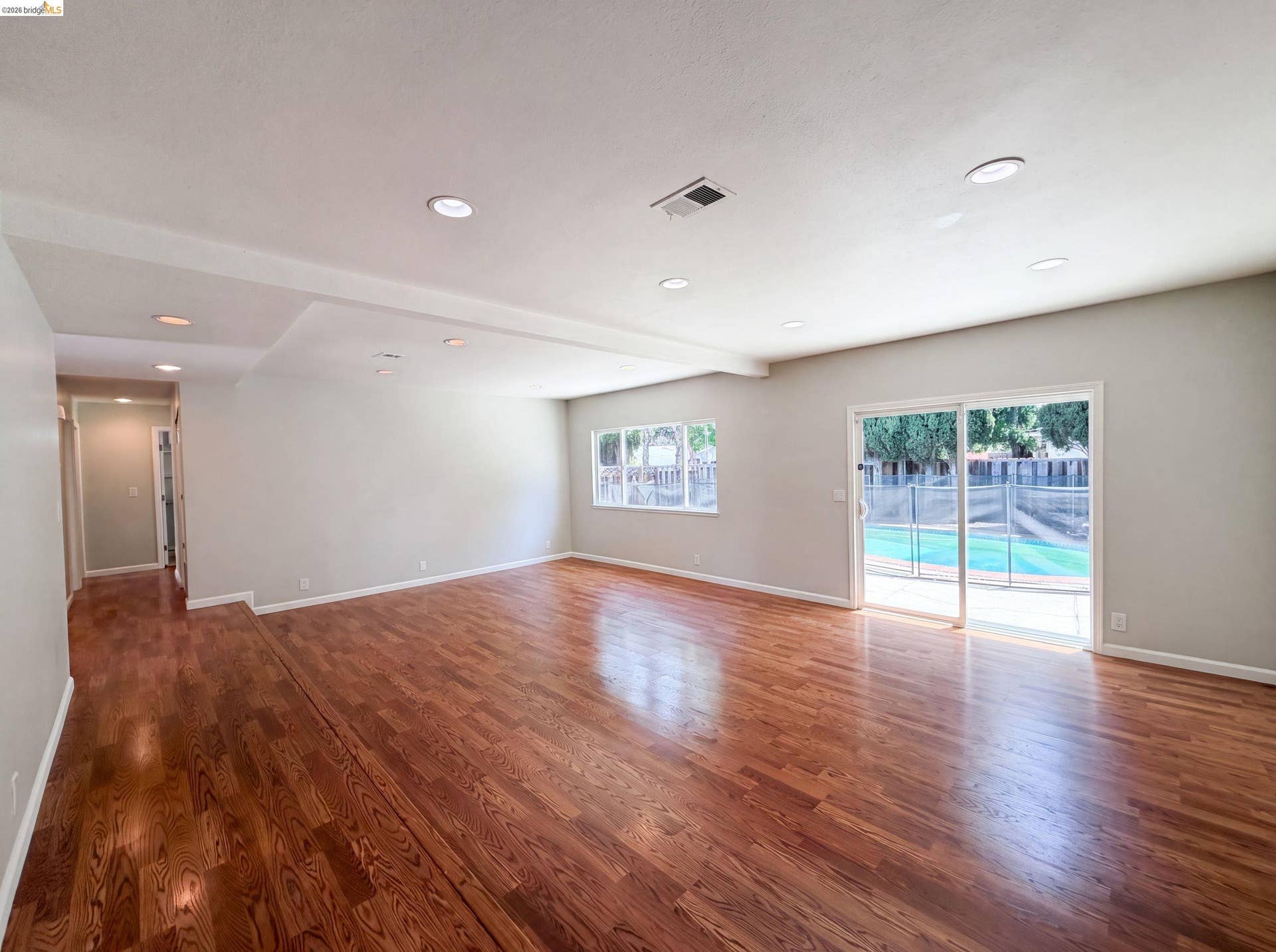 Spacious interior featuring wood-finish flooring, recessed lighting, and light gray wall finishes