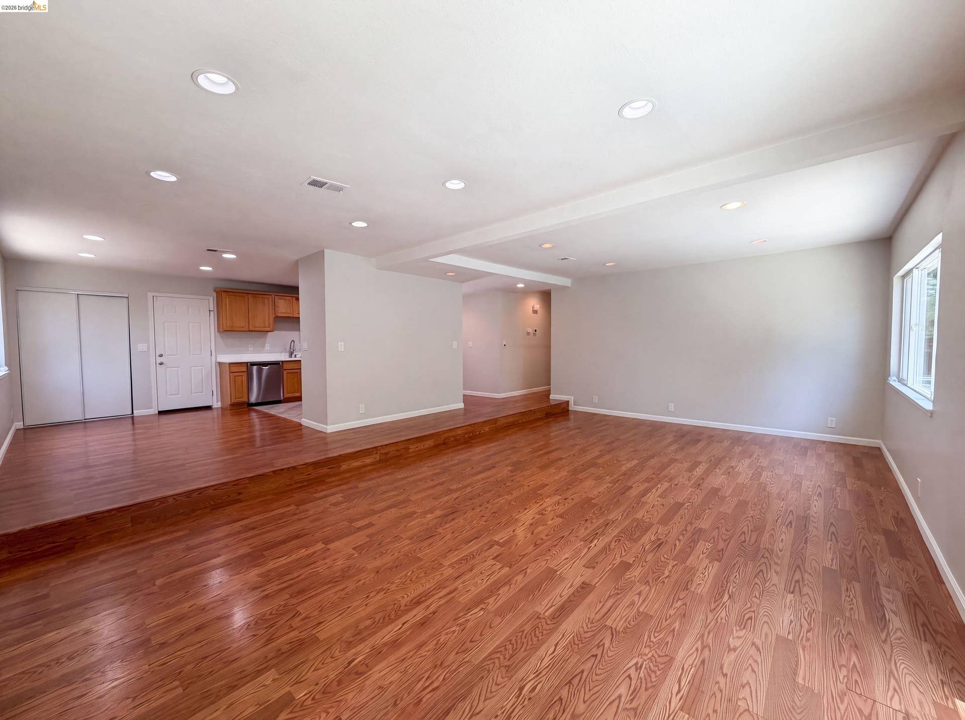 Spacious living area featuring wood-finish flooring and recessed lighting