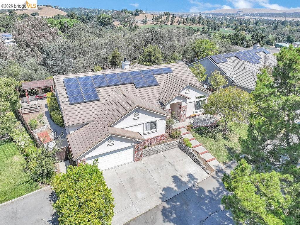 Single-story residence featuring a tile roof and solar panels
