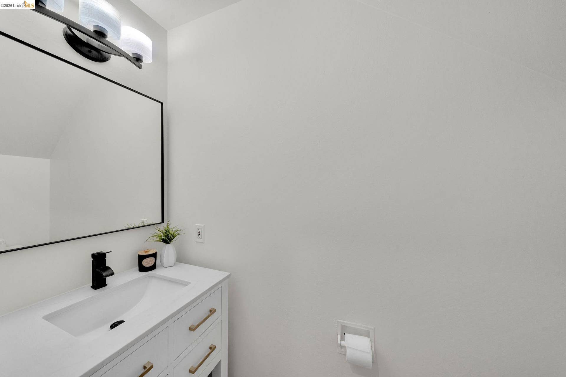 Vanity with integrated sink, matte black faucet, and brass hardware