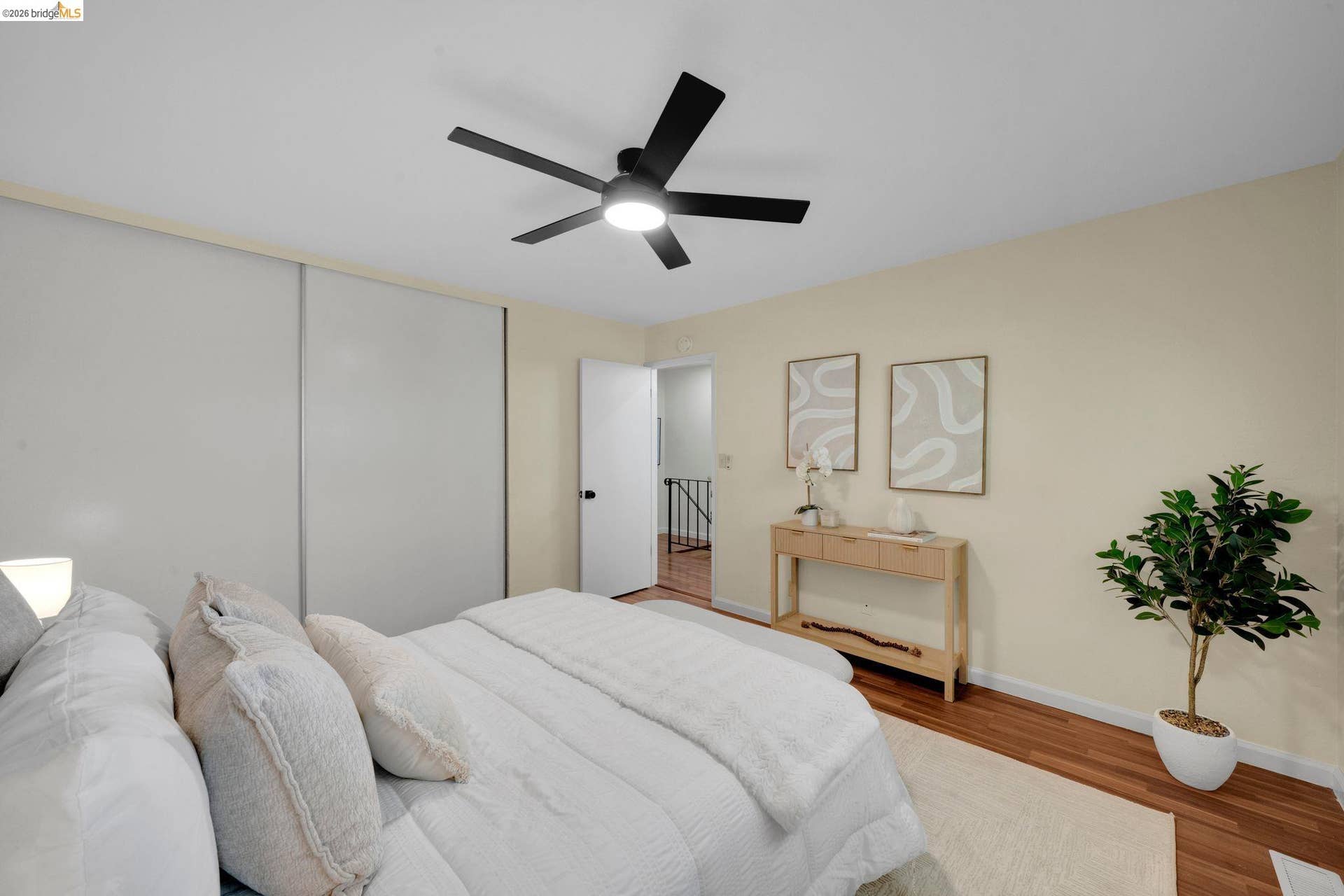 Ceiling fan with integrated lighting, wood-finish flooring, and light-toned walls