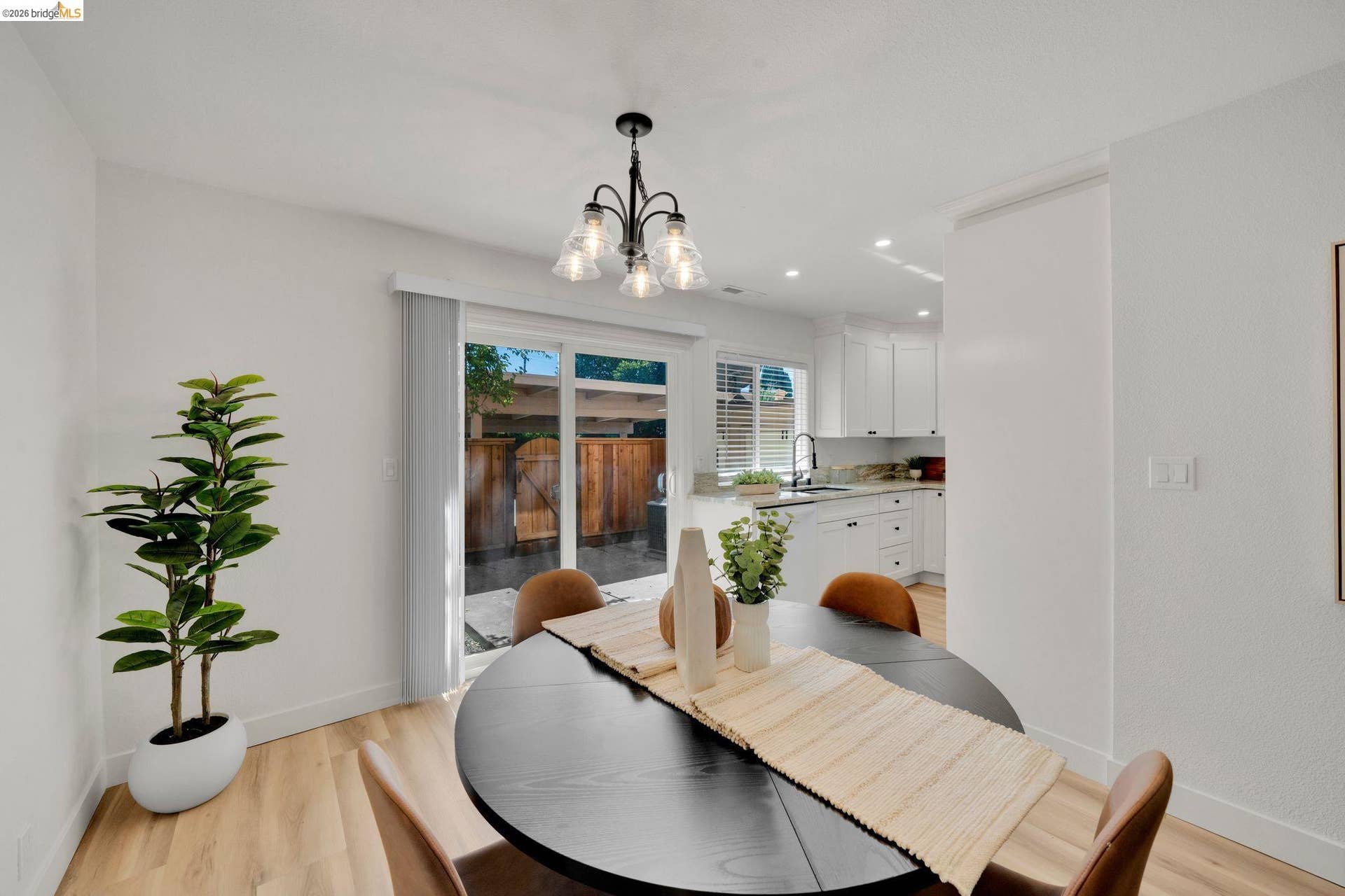 Recessed lighting, wood-finish flooring, and a modern chandelier