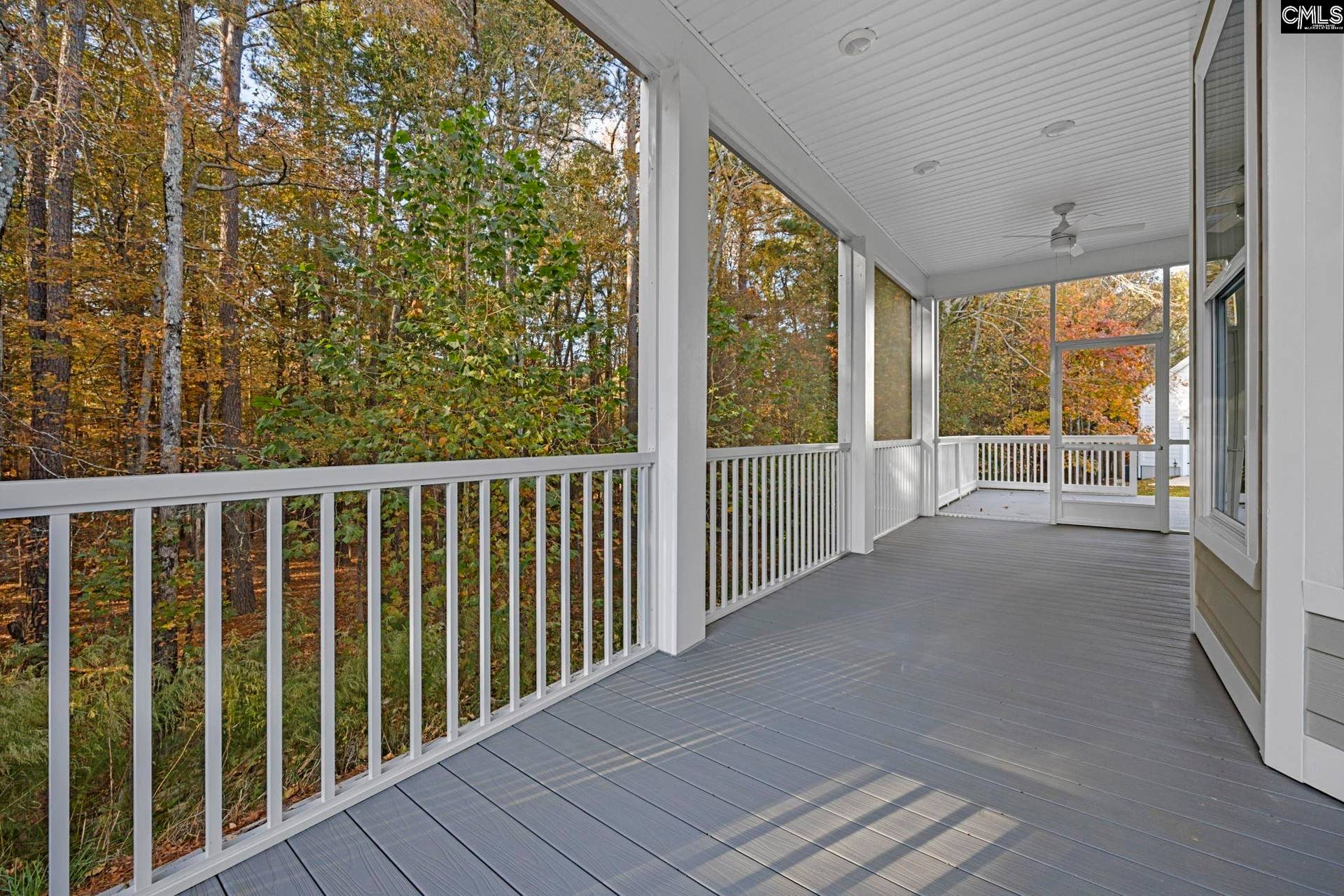 Private screened porch off the primary suite overlooks the peaceful wooded backdrop.