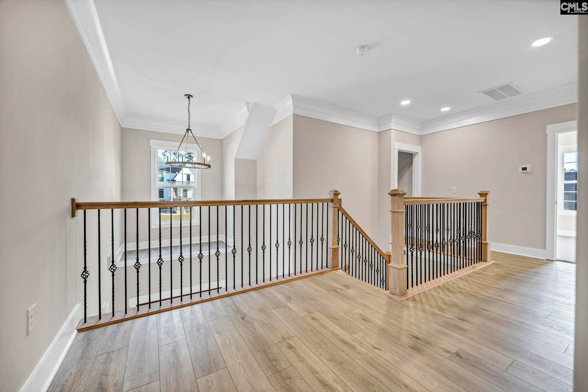 Open landing with wrought iron balusters, wood rails, LVP & the perfect Christmas tree spot!