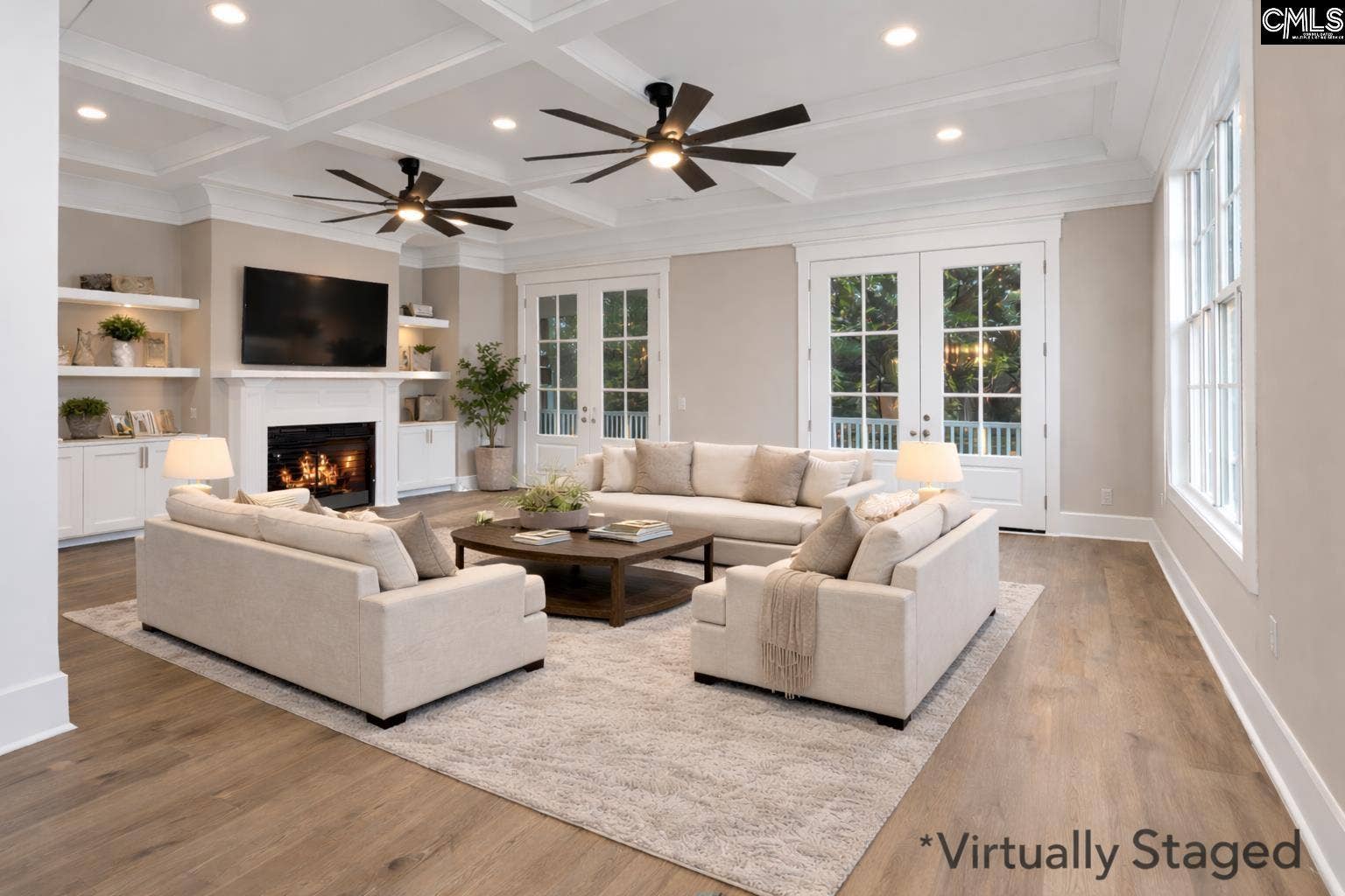 Spacious living room features a cozy fireplace flanked by built-in bookshelves and abundant windows.