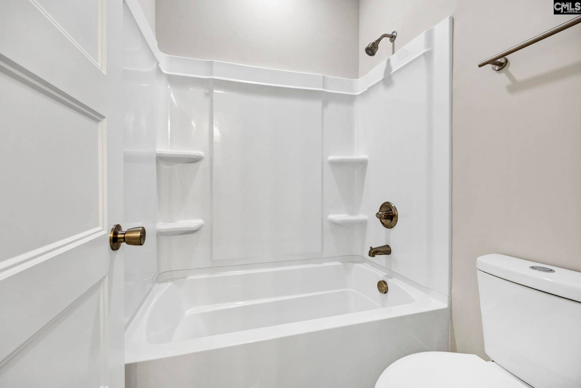 Jack & Jill bath features a tub/shower combination with built-in shelving for convenient storage.