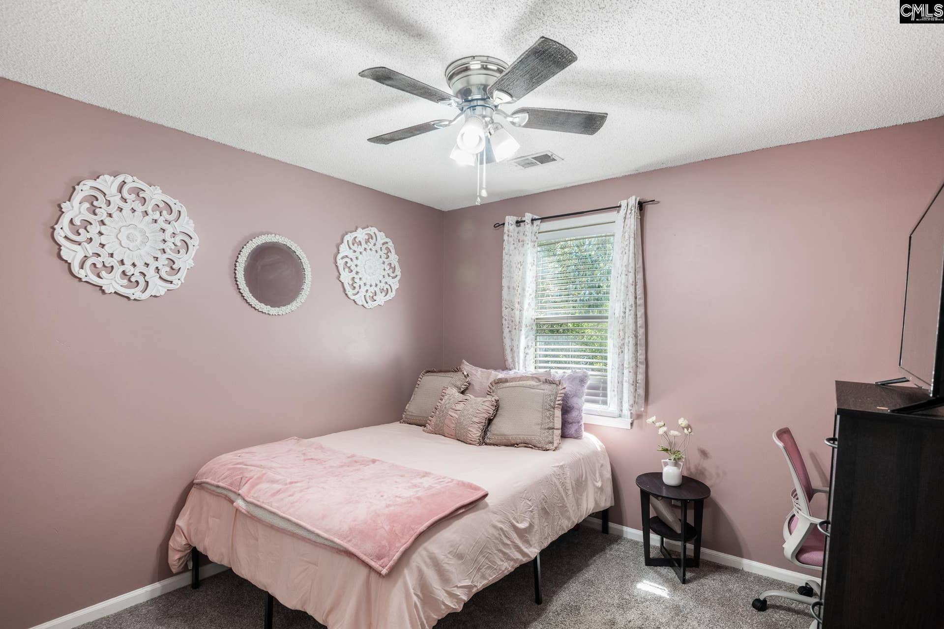 Bedroom with a ceiling fan and natural light
