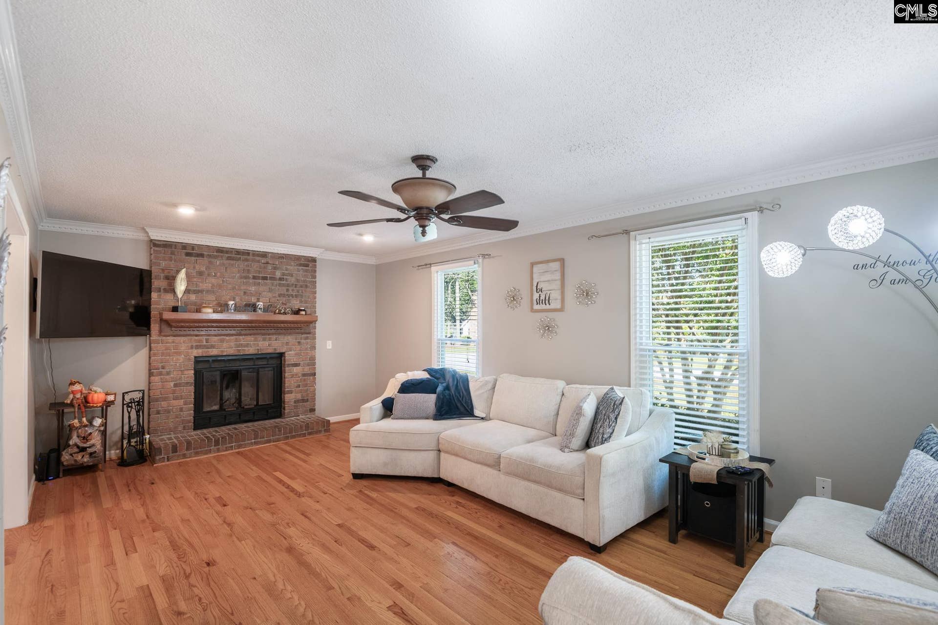Hardwood floors, crown molding and a brick wood-burning fireplace