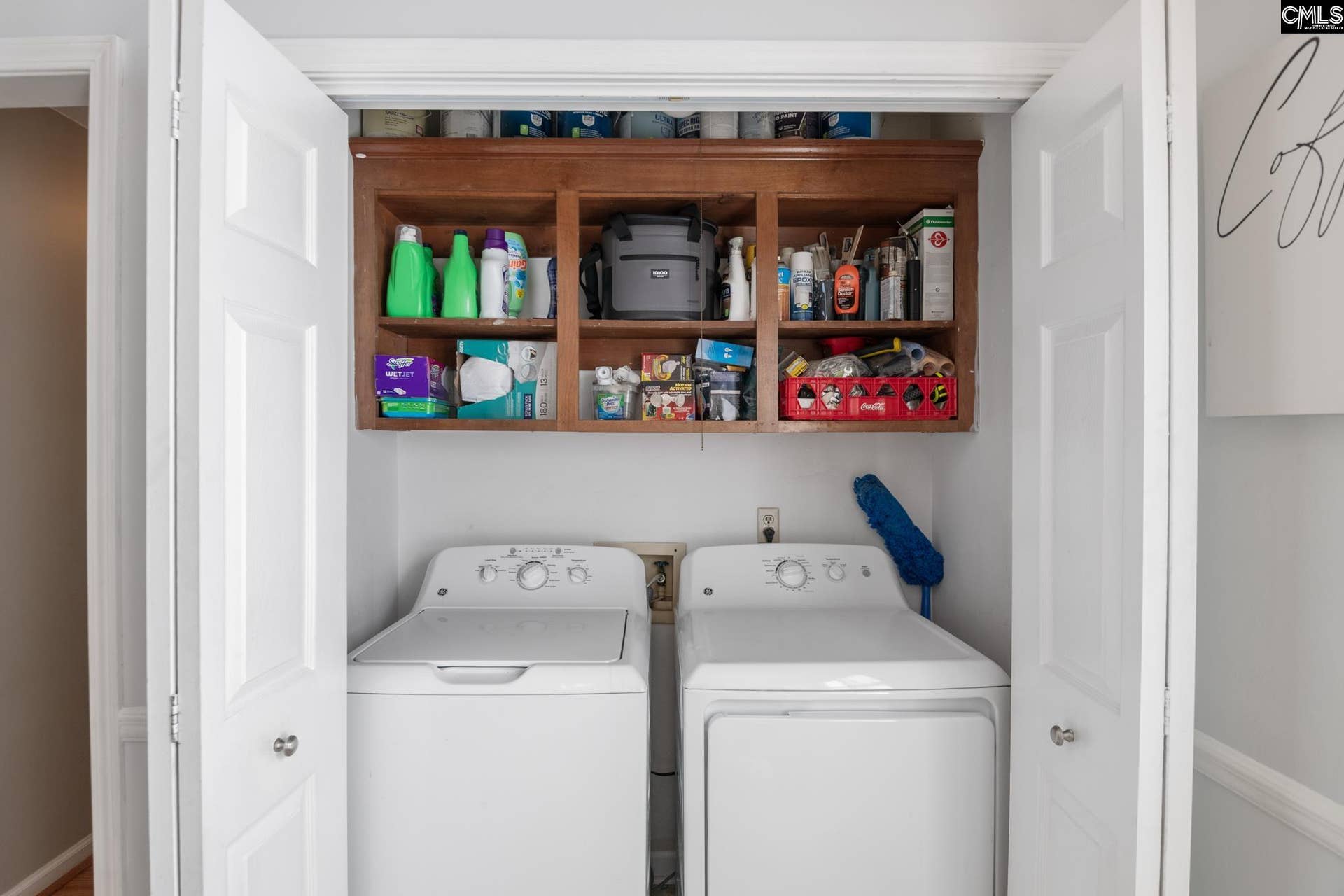 Laundry closet with built-in shelving. Washer and dryer remain