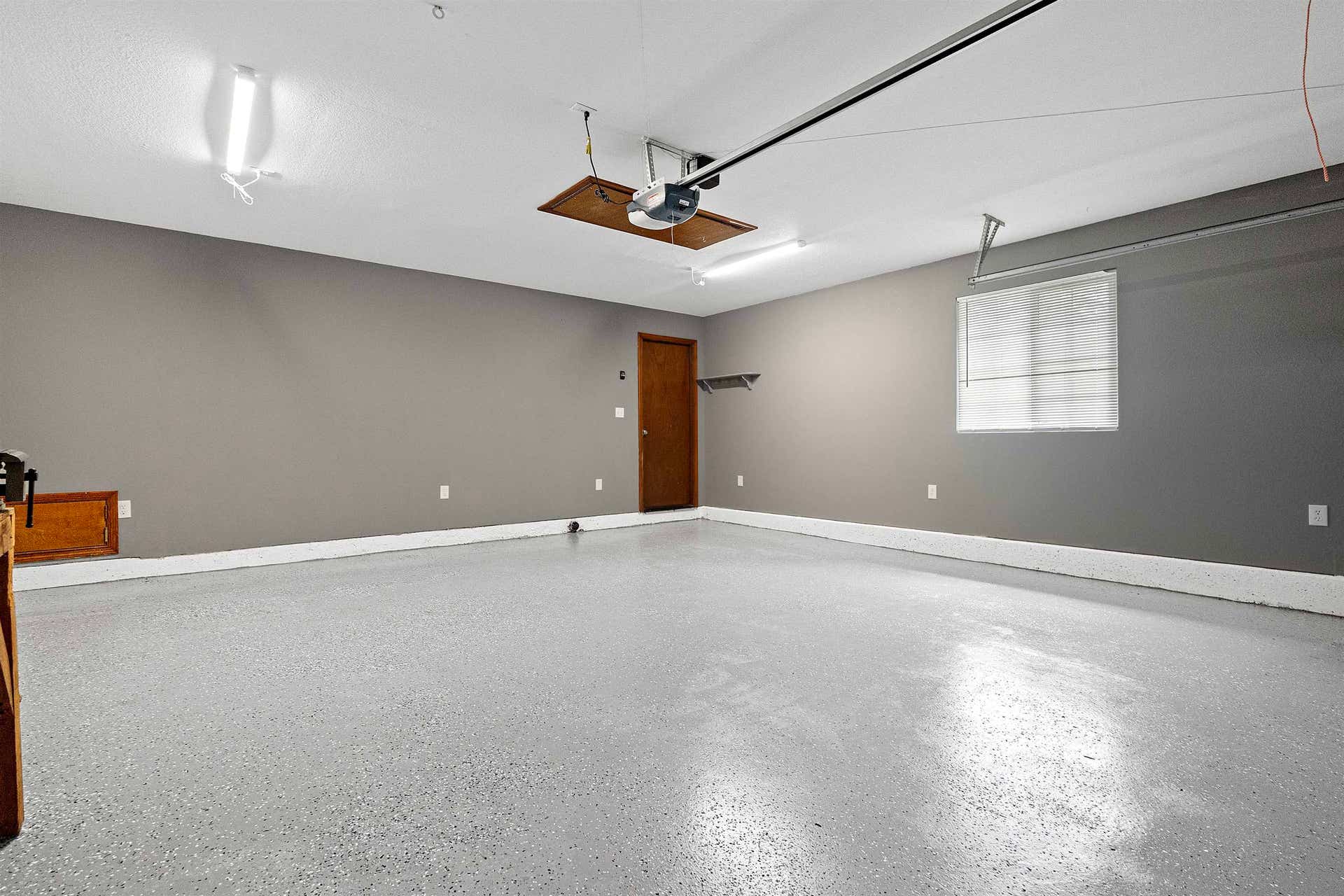 Spacious attached garage w/opener has pull-down ladder to access extra storage space.